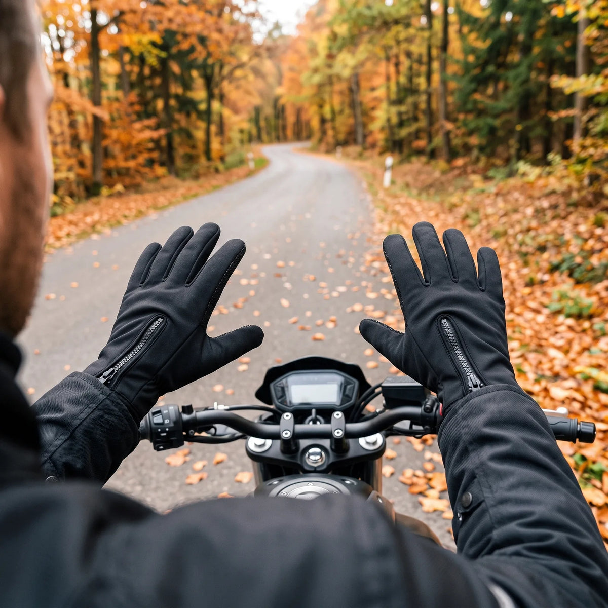 Motorradfahrer in den beheizten Handschuhen Griff vor einer Fahrt auf einer herbstlichen Landstraße