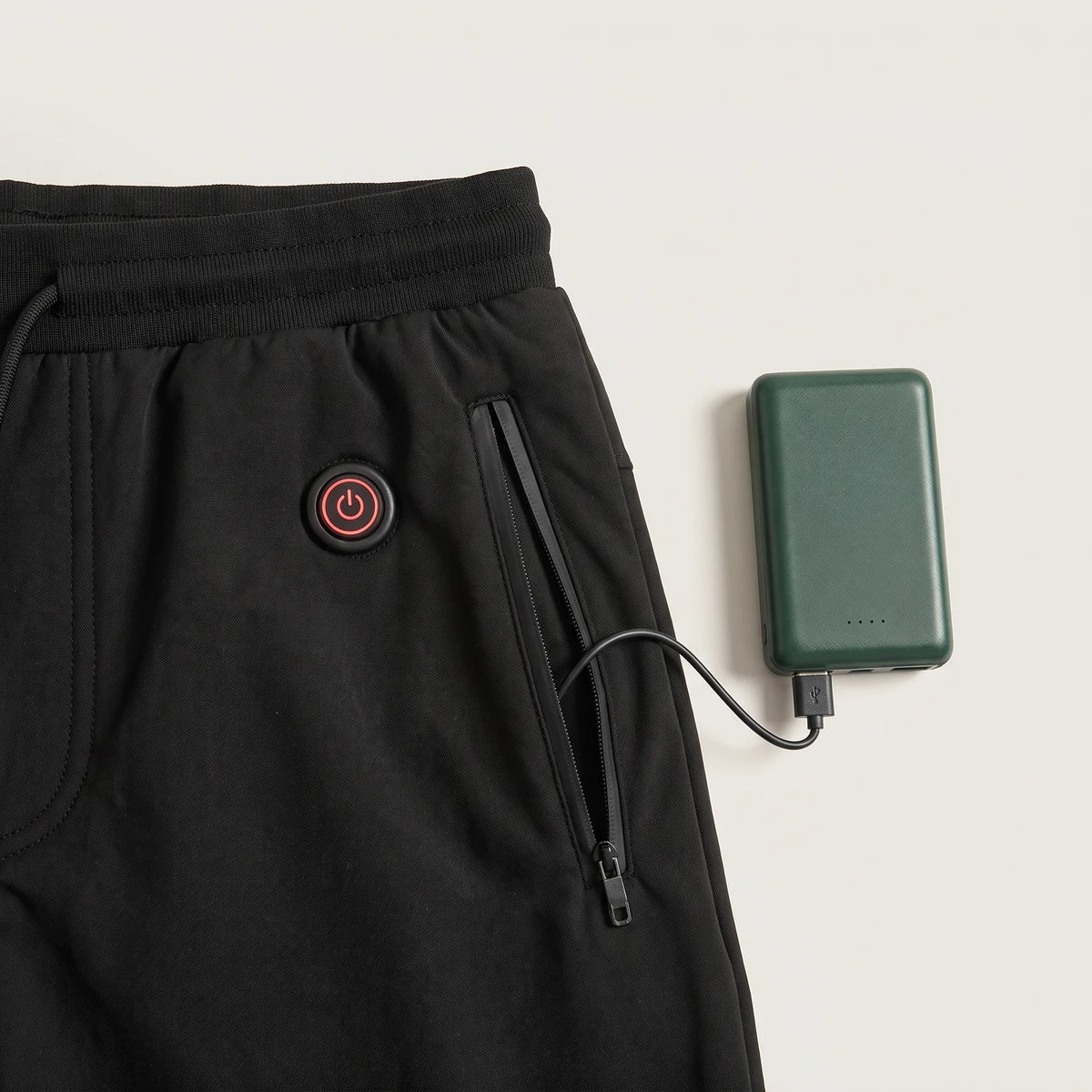 Heizknopf unter dem Bund und Tasche mit angeschlossener BergHeat Powerbank